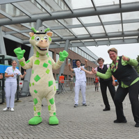 Freek de Giraffe en het team van de stichting voor de ingang van het ziekenhuis